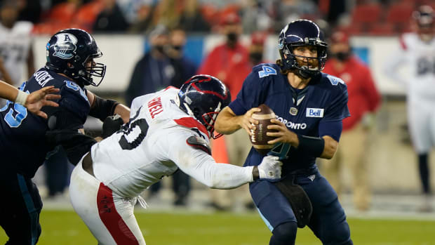 Sep 24, 2021; Toronto, Ontario, Canada; Montreal Alouettes defensive lineman Almondo Sewell (90) avoids a block by Toronto Argonauts offensive lineman Dariusz Bladek (65) to pressure quarterback McLeod Bethel-Thompson (4) during the second half at BMO Field. Mandatory Credit: John E. Sokolowski-USA TODAY Sports  